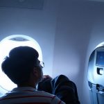 Passager installé dans un siège de classe économique sur un vol long-courrier